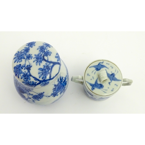 49 - A Chinese blue and white twin handled cup and cover decorated with cranes in flight with bamboo fini... 