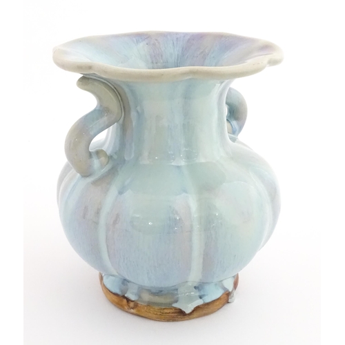 61 - A Chinese high fired twin handled vase of lobed form. Character marks under. Approx. 8 1/4