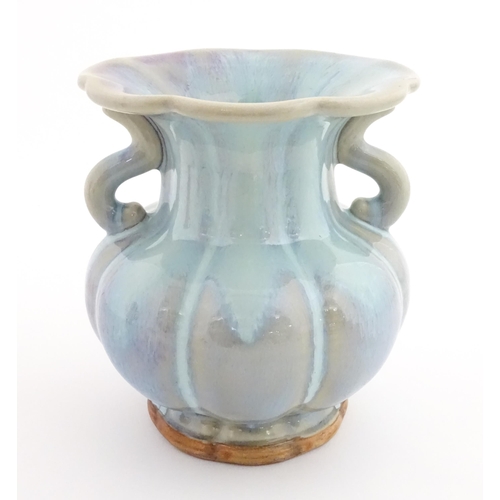 61 - A Chinese high fired twin handled vase of lobed form. Character marks under. Approx. 8 1/4