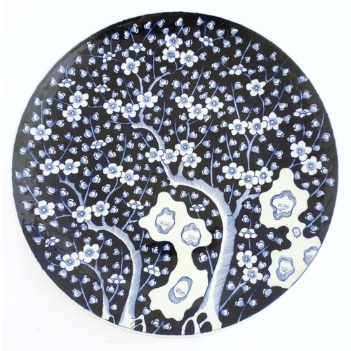 63A - A large Chinese blue and white charger decorated with prunus blossom and taihu rocks, with brushwork... 