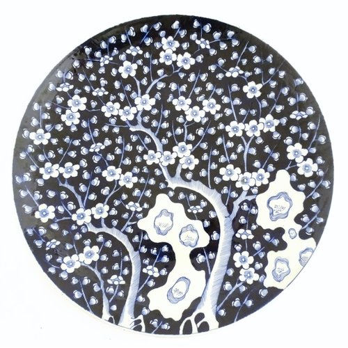 63A - A large Chinese blue and white charger decorated with prunus blossom and taihu rocks, with brushwork... 