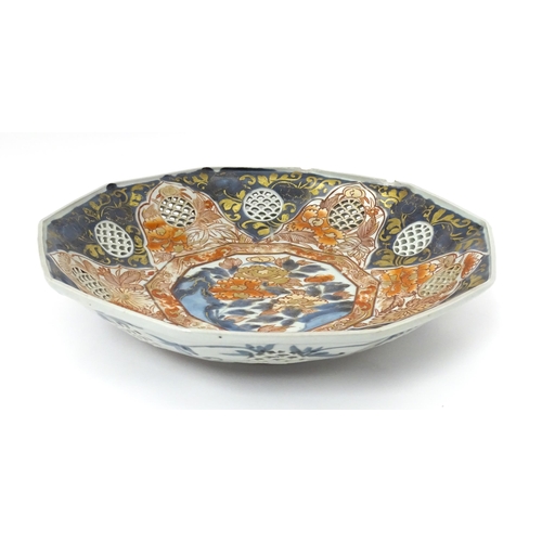 65A - A Japanese dish with ten sides decorated in the Imari palette with flowers and foliage, and ten roun... 