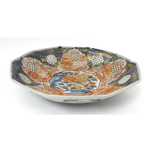 65A - A Japanese dish with ten sides decorated in the Imari palette with flowers and foliage, and ten roun... 