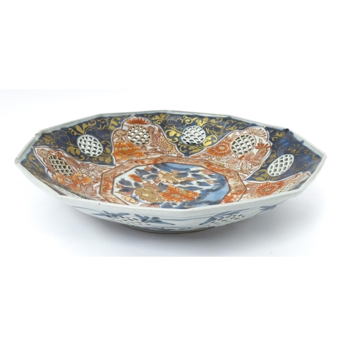 65A - A Japanese dish with ten sides decorated in the Imari palette with flowers and foliage, and ten roun... 
