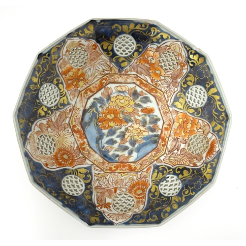 65A - A Japanese dish with ten sides decorated in the Imari palette with flowers and foliage, and ten roun... 