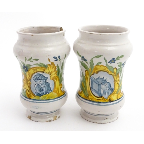90 - A pair of Italian maiolica albarelli / chemist / drug jars of waisted form, decorated with a portrai... 