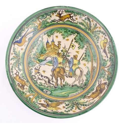 211 - A Spanish talavera / faience bowl by Pedro de la Cal depicting two knights on horseback and a dog ap... 