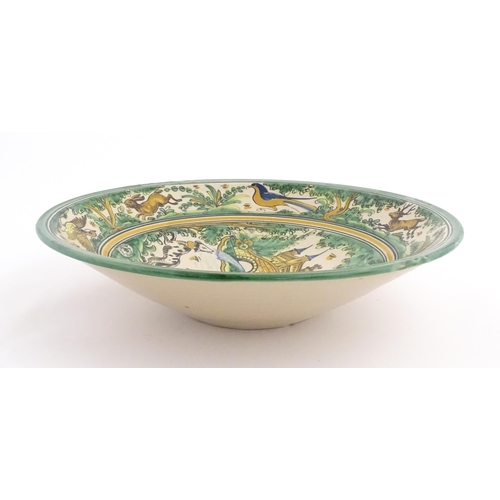 211 - A Spanish talavera / faience bowl by Pedro de la Cal depicting two knights on horseback and a dog ap... 