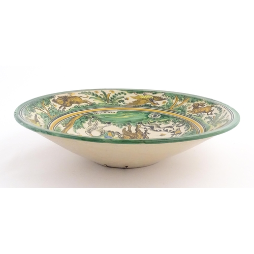 211 - A Spanish talavera / faience bowl by Pedro de la Cal depicting two knights on horseback and a dog ap... 