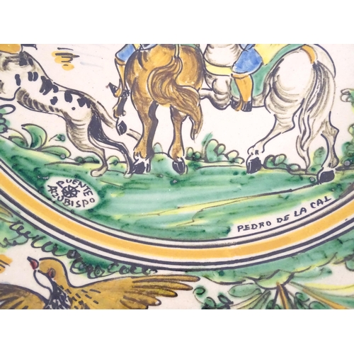 211 - A Spanish talavera / faience bowl by Pedro de la Cal depicting two knights on horseback and a dog ap... 