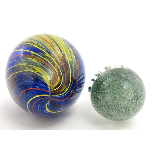 323 - An art glass paperweight of egg form with abstract coloured swirl detail. Together with a smaller gl... 