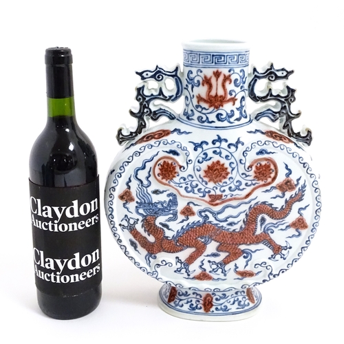 10 - A Chinese red, blue and white vase with scrolling twin handles, decorated with a dragon amongst styl... 