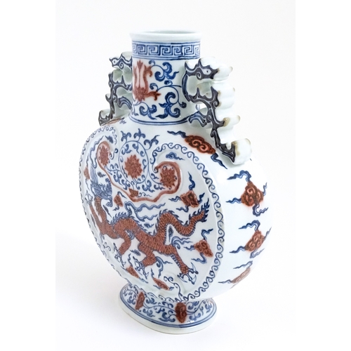 10 - A Chinese red, blue and white vase with scrolling twin handles, decorated with a dragon amongst styl... 