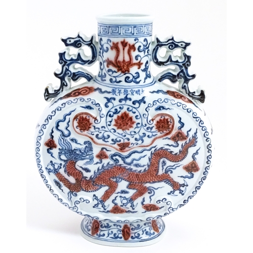 10 - A Chinese red, blue and white vase with scrolling twin handles, decorated with a dragon amongst styl... 