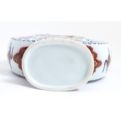 10 - A Chinese red, blue and white vase with scrolling twin handles, decorated with a dragon amongst styl... 