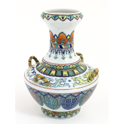 14 - A Chinese Doucai vase with four loop handles, decorated with stylised dragons and banded borders. Ch... 