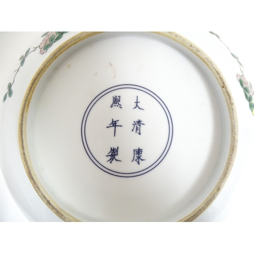 15 - A Chinese famille verte plate decorated with an Imperial figure with attendants. Character marks und... 