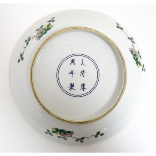 15 - A Chinese famille verte plate decorated with an Imperial figure with attendants. Character marks und... 