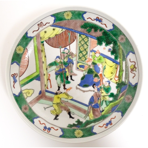15 - A Chinese famille verte plate decorated with an Imperial figure with attendants. Character marks und... 