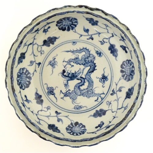 31 - Two Chinese blue and white dishes, to include on with dragon decoration to centre bordered by flower... 