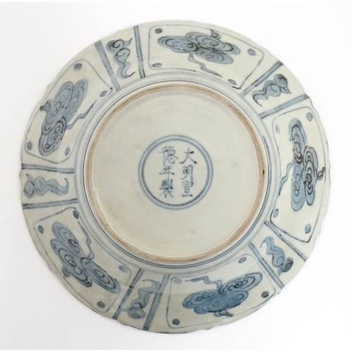 31 - Two Chinese blue and white dishes, to include on with dragon decoration to centre bordered by flower... 