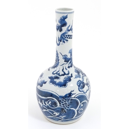 39 - A Chinese blue and white vase decorated with a dragon above waves with fish. Character marks under. ... 
