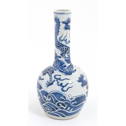 39 - A Chinese blue and white vase decorated with a dragon above waves with fish. Character marks under. ... 