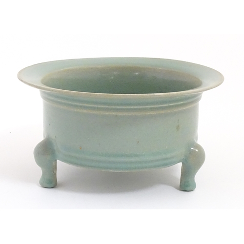 52 - A Chinese celadon planter raised on three feet. approx. 7 1/2