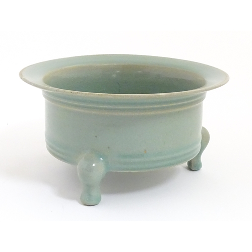 52 - A Chinese celadon planter raised on three feet. approx. 7 1/2