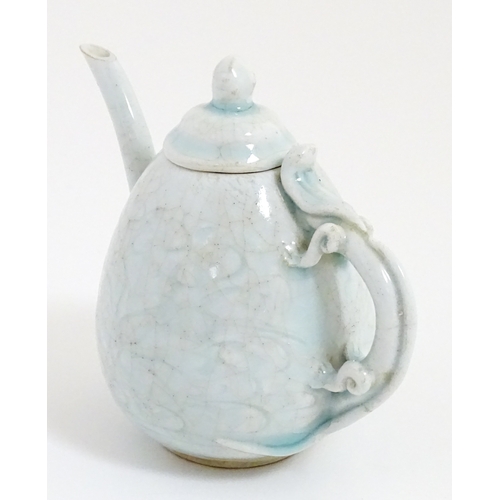 7 - A small Chinese teapot with scrolling detail. Approx. 4 1/2