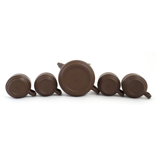 17 - A Chinese Yixing style tea set comprising teapot, four cups and a circular tray / dish. Impressed Ch... 