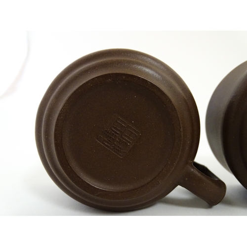 17 - A Chinese Yixing style tea set comprising teapot, four cups and a circular tray / dish. Impressed Ch... 