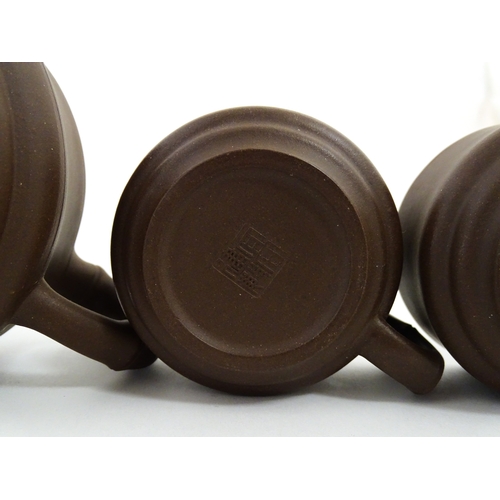 17 - A Chinese Yixing style tea set comprising teapot, four cups and a circular tray / dish. Impressed Ch... 