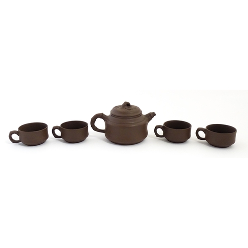 17 - A Chinese Yixing style tea set comprising teapot, four cups and a circular tray / dish. Impressed Ch... 