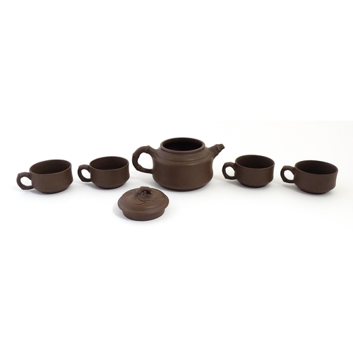 17 - A Chinese Yixing style tea set comprising teapot, four cups and a circular tray / dish. Impressed Ch... 