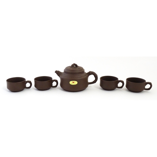 17 - A Chinese Yixing style tea set comprising teapot, four cups and a circular tray / dish. Impressed Ch... 