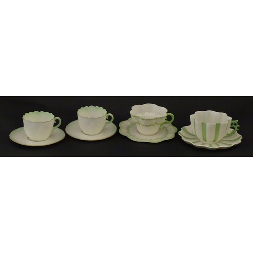 82 - Two Belleek Lily pattern cups and saucers with green highlights. Together with a Belleek 5 O'Clock p... 