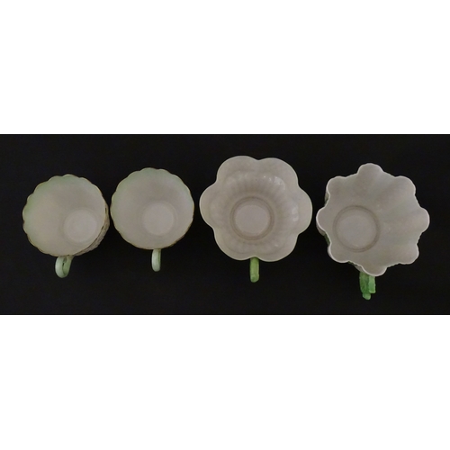 82 - Two Belleek Lily pattern cups and saucers with green highlights. Together with a Belleek 5 O'Clock p... 