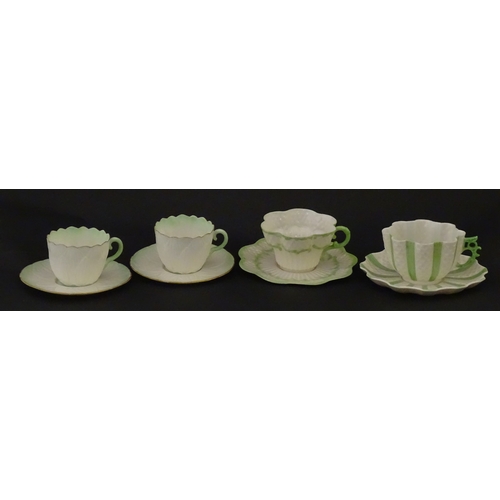 82 - Two Belleek Lily pattern cups and saucers with green highlights. Together with a Belleek 5 O'Clock p... 