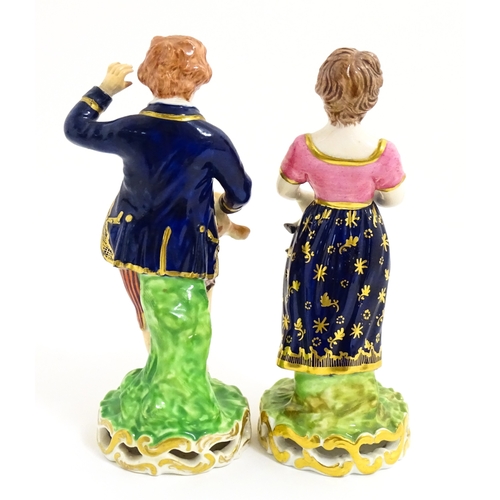 104 - A pair of Derby figures modelled as a boy holding a dog, and a girl holding a lamb. Marked under. Ap... 
