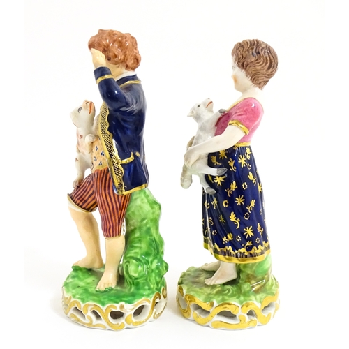 104 - A pair of Derby figures modelled as a boy holding a dog, and a girl holding a lamb. Marked under. Ap... 