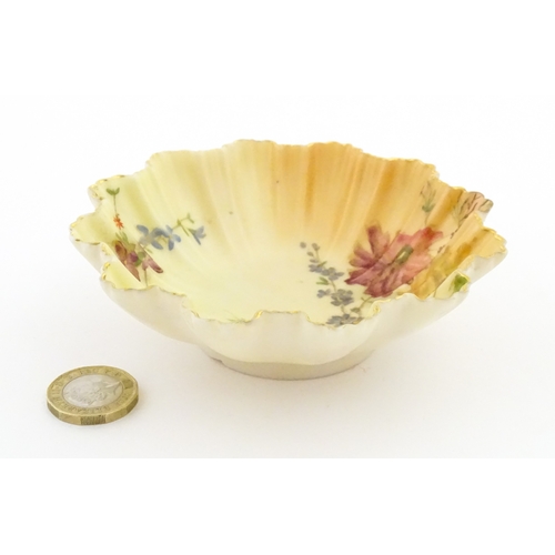 117 - A Royal Worcester blush ivory dish of frilled shell form decorated with flowers. Marked under and nu... 