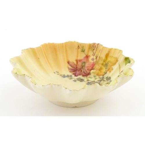 117 - A Royal Worcester blush ivory dish of frilled shell form decorated with flowers. Marked under and nu... 