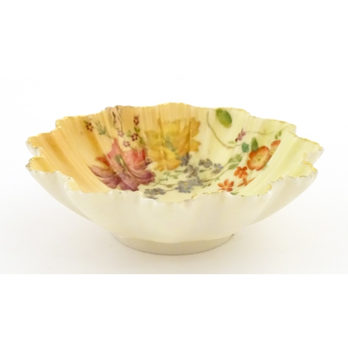 117 - A Royal Worcester blush ivory dish of frilled shell form decorated with flowers. Marked under and nu... 