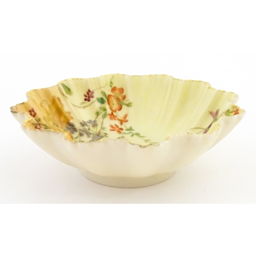 117 - A Royal Worcester blush ivory dish of frilled shell form decorated with flowers. Marked under and nu... 