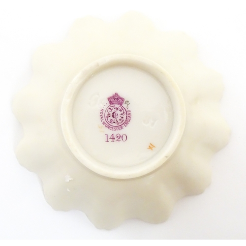 117 - A Royal Worcester blush ivory dish of frilled shell form decorated with flowers. Marked under and nu... 
