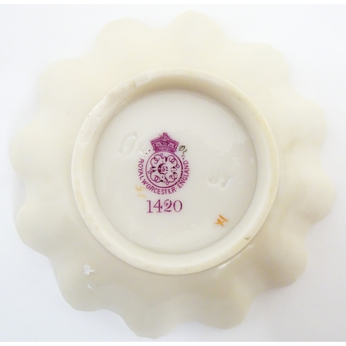 117 - A Royal Worcester blush ivory dish of frilled shell form decorated with flowers. Marked under and nu... 