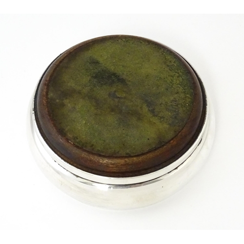 354 - A silver bottle coaster with turned wooden base, hallmarked Birmingham 1999, maker W I Broadway & Co... 