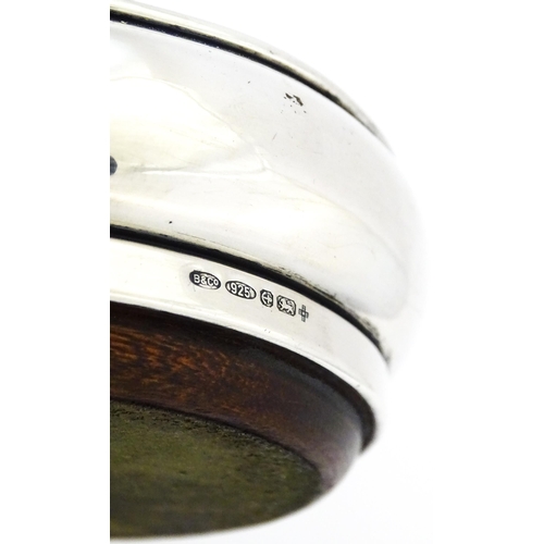 354 - A silver bottle coaster with turned wooden base, hallmarked Birmingham 1999, maker W I Broadway & Co... 