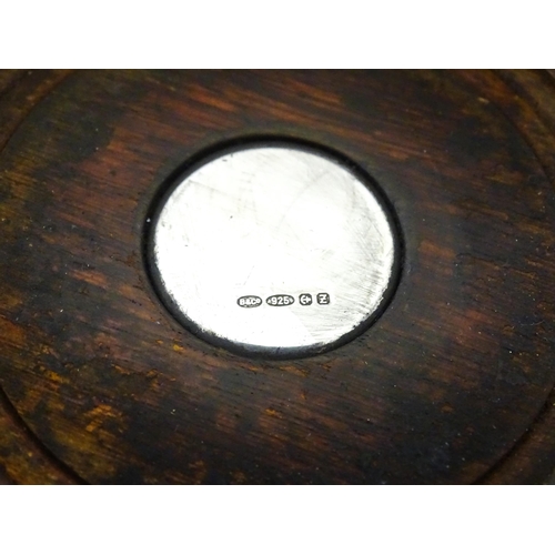354 - A silver bottle coaster with turned wooden base, hallmarked Birmingham 1999, maker W I Broadway & Co... 